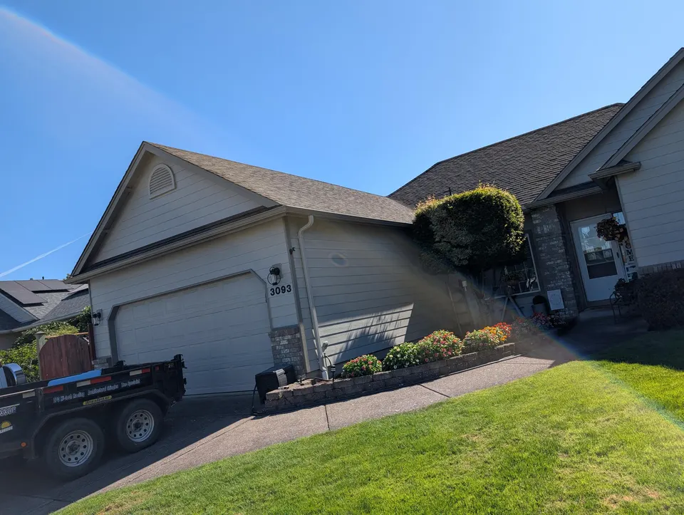 Completed residential roof with Rain or Shine Roofing trailer on site