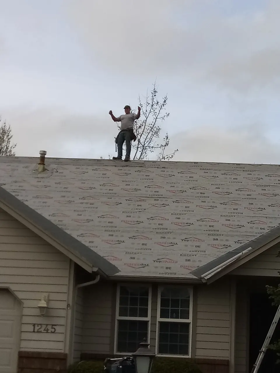 Rain or Shine roofer on the ridge with TopShield underlayment during a Willamette Valley install