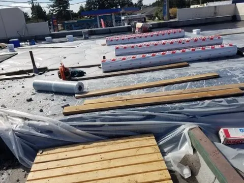 Roofing supplies staged on a residential roof during a tear-off