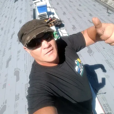 Tim, owner of Rain or Shine Roofing, working on a roof in Oregon